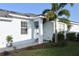 Inviting home exterior featuring a light blue facade, manicured lawn, and a lovely tropical palm tree at 17817 Woodland Ct, Punta Gorda, FL 33982