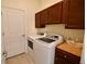 Well-organized laundry room featuring a modern washer and dryer, ample storage, and neutral color scheme at 17817 Woodland Ct, Punta Gorda, FL 33982