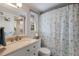 Well-lit bathroom with a vanity, toilet, shower with a starfish-themed curtain, and a window at 205 Highland Ave # 2, Bradenton Beach, FL 34217