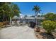 Private patio featuring a grill and lounge chairs, surrounded by lush landscaping and a secure fence at 205 Highland Ave # 2, Bradenton Beach, FL 34217