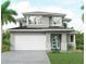 Modern two-story home featuring gray siding, stone accents, a two-car garage, and a bright blue front door at 2563 Loma Linda St, Sarasota, FL 34239