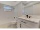 Updated bathroom featuring white vanity, black fixtures, marble floors, and a tub with shower at 2924 Valley Forge St, Sarasota, FL 34231