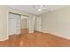Bedroom featuring hardwood floors, sliding closet doors with mirrors, a ceiling fan, and an open doorway at 2924 Valley Forge St, Sarasota, FL 34231