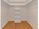 Walk-in closet with hardwood floors, built-in shelving, and rods for hanging clothes at 2924 Valley Forge St, Sarasota, FL 34231