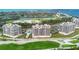 Expansive aerial shot of beachfront condos overlooking lush golf course and serene ocean waters at 3030 Grand Bay Blvd # 323, Longboat Key, FL 34228
