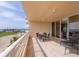 Large balcony with outdoor furniture and views of the water and a lush green golf course at 3030 Grand Bay Blvd # 323, Longboat Key, FL 34228