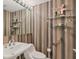 Cozy bathroom with striped wallpaper and floating shelves at 3030 Grand Bay Blvd # 323, Longboat Key, FL 34228