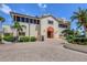 Clubhouse exterior with a covered entrance, well-manicured landscaping, and a paved drive at 3030 Grand Bay Blvd # 323, Longboat Key, FL 34228