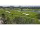 An aerial shot of a sprawling golf course, showcasing its lush fairways, sand traps, and serene water features at 3030 Grand Bay Blvd # 323, Longboat Key, FL 34228