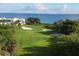 Inviting view of a lush golf course with scenic sand traps and glimpses of the ocean from the community at 3030 Grand Bay Blvd # 323, Longboat Key, FL 34228