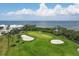 Scenic view of lush green golf course with sandy areas near waterfront homes and ocean backdrop at 3030 Grand Bay Blvd # 323, Longboat Key, FL 34228