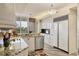 Open kitchen with stainless steel appliances, granite counters, and access to a balcony at 3030 Grand Bay Blvd # 323, Longboat Key, FL 34228