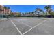 Well-maintained tennis court with lush landscaping and a clear blue sky in the background at 3030 Grand Bay Blvd # 323, Longboat Key, FL 34228
