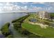 Beautiful view of the golf course and waterfront with condos, palm trees and native foliage on a sunny day at 3030 Grand Bay Blvd # 323, Longboat Key, FL 34228