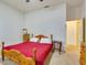 Bedroom features a bed with a red cover, a wooden frame, and minimalist decor at 361 Whitfield Ave, Sarasota, FL 34243