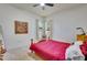Bedroom features a bed with a red cover, a wooden frame, minimalist decor, and natural light at 361 Whitfield Ave, Sarasota, FL 34243