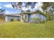 Exterior view featuring arched windows, lush landscaping, and a well-maintained lawn at 361 Whitfield Ave, Sarasota, FL 34243