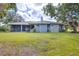 Rear exterior view of the home highlighting the screened lanai and lush greenery in the backyard at 361 Whitfield Ave, Sarasota, FL 34243