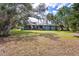 Back exterior view of a home showcasing the screened patio and large, lush yard at 361 Whitfield Ave, Sarasota, FL 34243