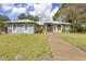 Charming one-story home with lush lawn, mature trees, and a welcoming entrance at 361 Whitfield Ave, Sarasota, FL 34243