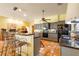 Bright kitchen with tile floors, gray cabinets, stainless appliances, breakfast bar, and granite countertops at 361 Whitfield Ave, Sarasota, FL 34243