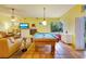 Bright living room with fireplace, television, tan sofas, tile floors, and a billiards table at 361 Whitfield Ave, Sarasota, FL 34243