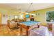 Open living room with fireplace, television, tan sofas, tile floors, and a billiards table at 361 Whitfield Ave, Sarasota, FL 34243
