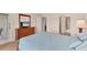 Bright bedroom with light blue bedding, dresser with mirror, and a door leading to an outdoor seating area at 4017 Crockers Lake Blvd # 1421, Sarasota, FL 34238