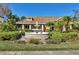 Community clubhouse entrance with fountain surrounded by lush landscaping and blue sky above at 4017 Crockers Lake Blvd # 1421, Sarasota, FL 34238