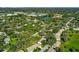 Aerial view showcasing the neighborhood's mature trees and lake at 4172 Oakhurst W Cir, Sarasota, FL 34233