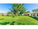 Expansive backyard with lush green grass and mature trees, perfect for outdoor activities at 4172 Oakhurst W Cir, Sarasota, FL 34233