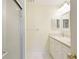 Bright bathroom featuring a shower, white cabinets, and a sleek countertop with dual sinks at 4172 Oakhurst W Cir, Sarasota, FL 34233
