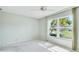 Well-lit bedroom featuring a large window with a view of the landscaped yard at 4172 Oakhurst W Cir, Sarasota, FL 34233
