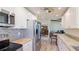 Bright kitchen features white cabinets, stainless steel appliances, and beautiful wood-look tile flooring at 4172 Oakhurst W Cir, Sarasota, FL 34233