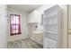 Practical laundry room is equipped with a utility sink, storage shelves and ample space at 4172 Oakhurst W Cir, Sarasota, FL 34233