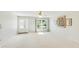 The living room has neutral paint and new carpet with a large window to let in natural light at 4172 Oakhurst W Cir, Sarasota, FL 34233