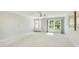 Living room with light, neutral carpet, large window, and entry way at 4172 Oakhurst W Cir, Sarasota, FL 34233