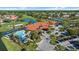 Aerial view of a clubhouse with a pool, tennis courts, and golf course, surrounded by a residential community at 4210 Caddie E Dr # 201, Bradenton, FL 34203