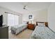 Cozy bedroom featuring two twin beds with matching bedspreads, a ceiling fan, and a bedside table with a lamp at 4210 Caddie E Dr # 201, Bradenton, FL 34203