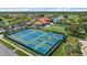 Aerial view highlighting the community clubhouse, tennis courts, golf course, and a scenic pond at 4210 Caddie E Dr # 201, Bradenton, FL 34203