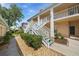 Exterior of condo building with white stairs and mature landscaping with stone at 4210 Caddie E Dr # 201, Bradenton, FL 34203