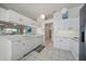 White kitchen with updated appliances, tile flooring, and adjacent pass-through counter to living area at 4210 Caddie E Dr # 201, Bradenton, FL 34203