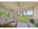 Relaxing enclosed lanai featuring wicker furniture and large windows with views of the lush green outdoor area at 4210 Caddie E Dr # 201, Bradenton, FL 34203
