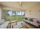 Relaxing enclosed lanai featuring wicker furniture and large windows with views of the lush green outdoor area at 4210 Caddie E Dr # 201, Bradenton, FL 34203