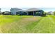 Expansive green backyard featuring manicured lawn, neighboring houses, and covered back porch at 4308 Fly Rod Ter, Parrish, FL 34219
