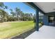 Expansive backyard with green lawn and lush trees, viewed from the covered patio at 4308 Fly Rod Ter, Parrish, FL 34219