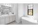 Bright bathroom featuring a soaking tub, vanity with modern fixtures, and natural light at 4308 Fly Rod Ter, Parrish, FL 34219