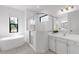 Bright bathroom featuring a soaking tub, glass shower, and vanity with modern fixtures at 4308 Fly Rod Ter, Parrish, FL 34219