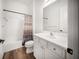 Clean bathroom with white vanity, toilet, shower-tub combo and wood-style flooring at 4308 Fly Rod Ter, Parrish, FL 34219