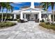 Inviting clubhouse entrance featuring an outdoor fireplace, ample seating, and lush tropical landscaping at 4308 Fly Rod Ter, Parrish, FL 34219